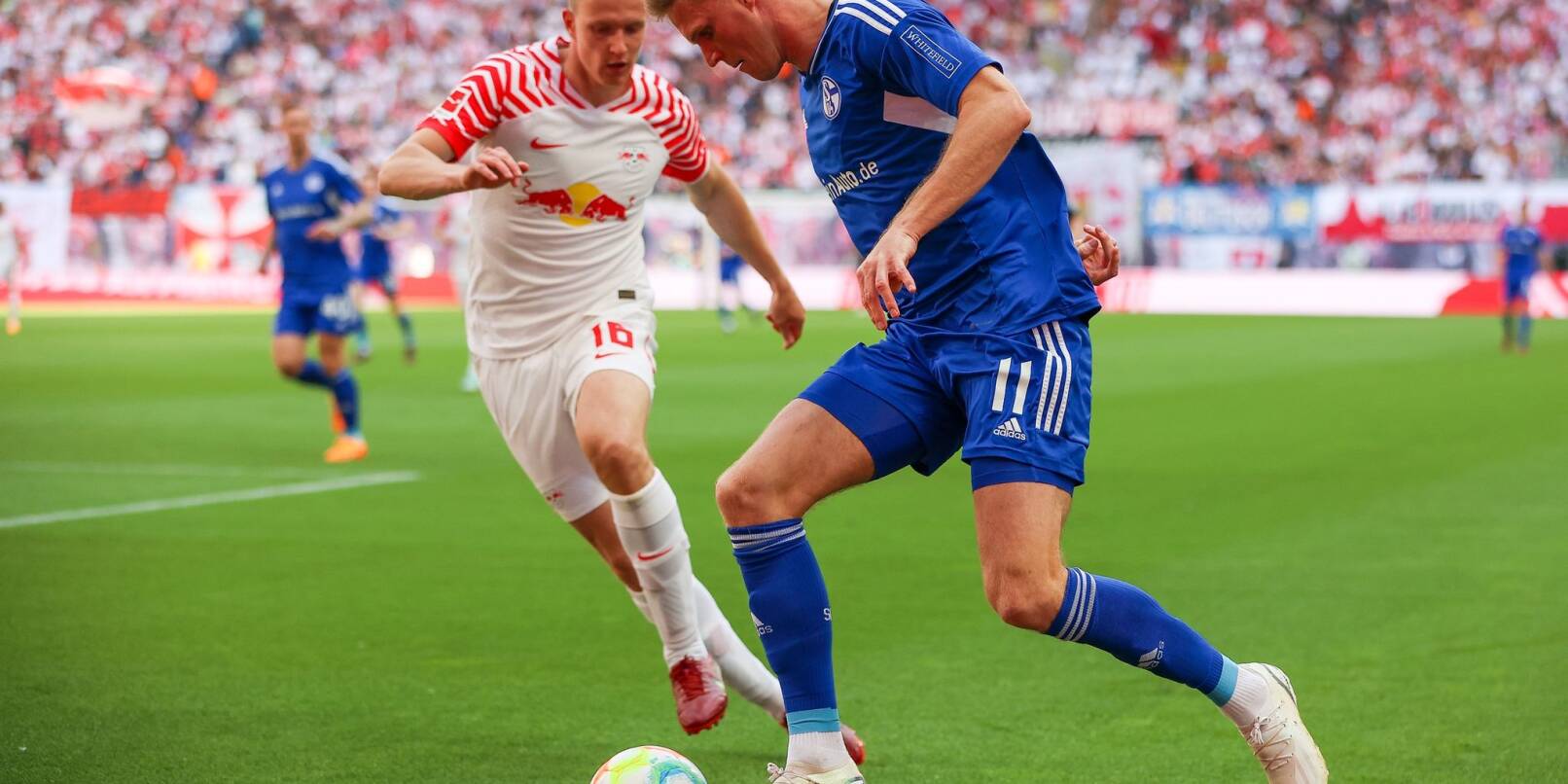 Leipzigs Lukas Klostermann (l) und Schalkes Marius Bülter im Duell.