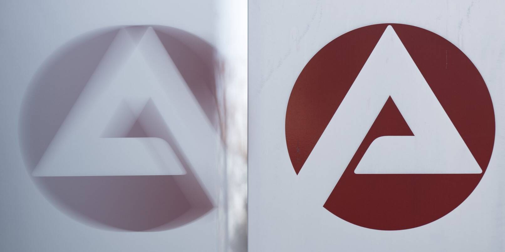 Das Logo der Bundesagentur für Arbeit spiegelt sich in einer Scheibe.