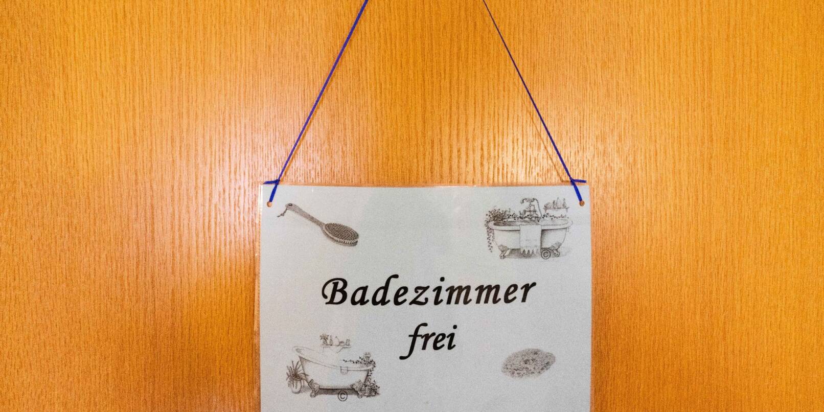Ein Schild mit der Aufschrift "Badezimmer frei" hängt im Altenheim St. Lioba an einer Tür.