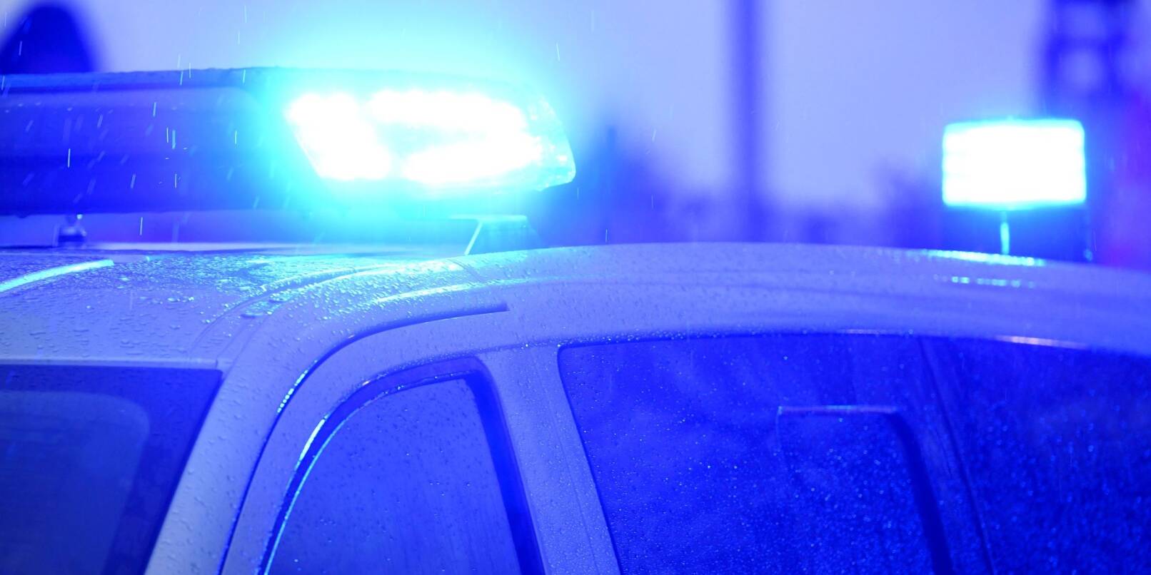Blaulichter leuchten auf dem Dach eines Streifenwagens der Polizei.