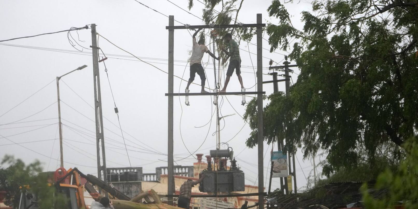 Arbeiter reparieren in Mandvi im indischen Bundesstaat Gujarat einen Transformator, um die Stromversorgung wiederherzustellen.