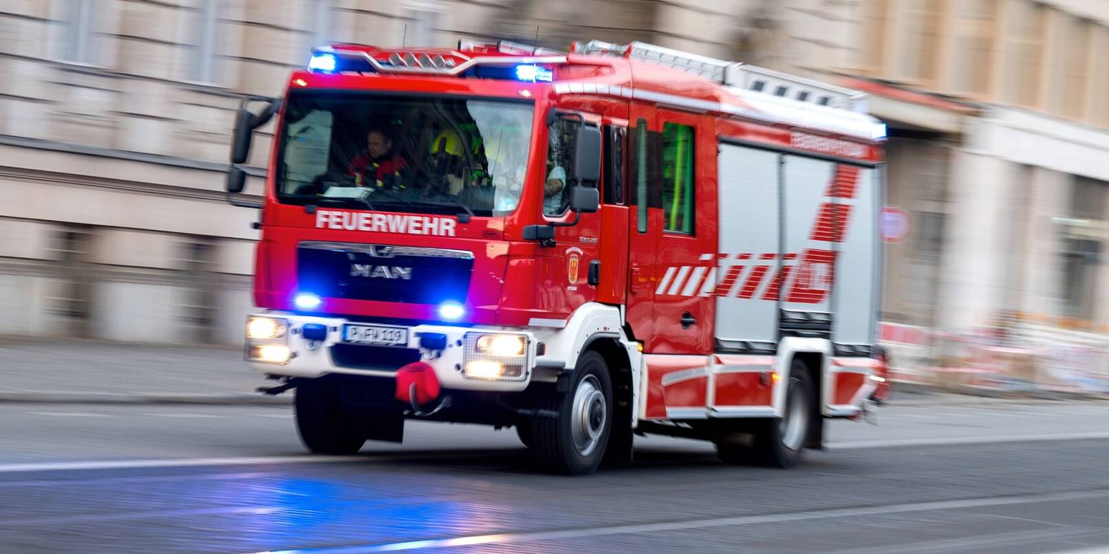 Ein Feuerwehrfahrzeug ist mit Blaulicht auf Einsatzfahrt.