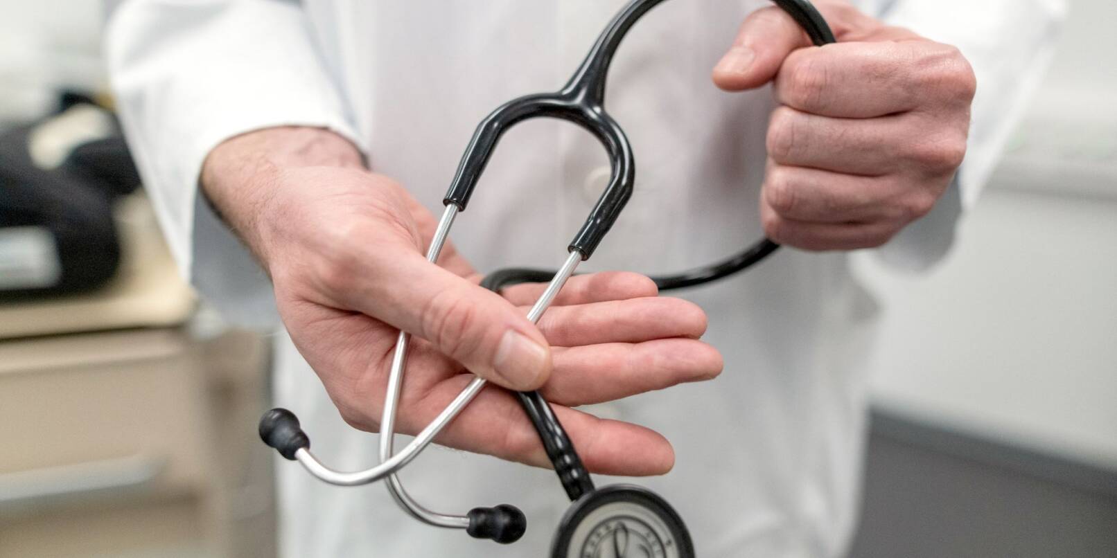Ein Arzt hält ein Stethoskop in der Hand.