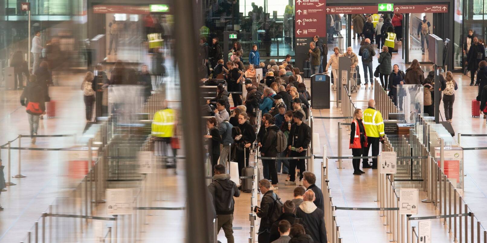 Reisende während des bundesweiten Warnstreiks an den Kontrollstellen im Flughafen BER.