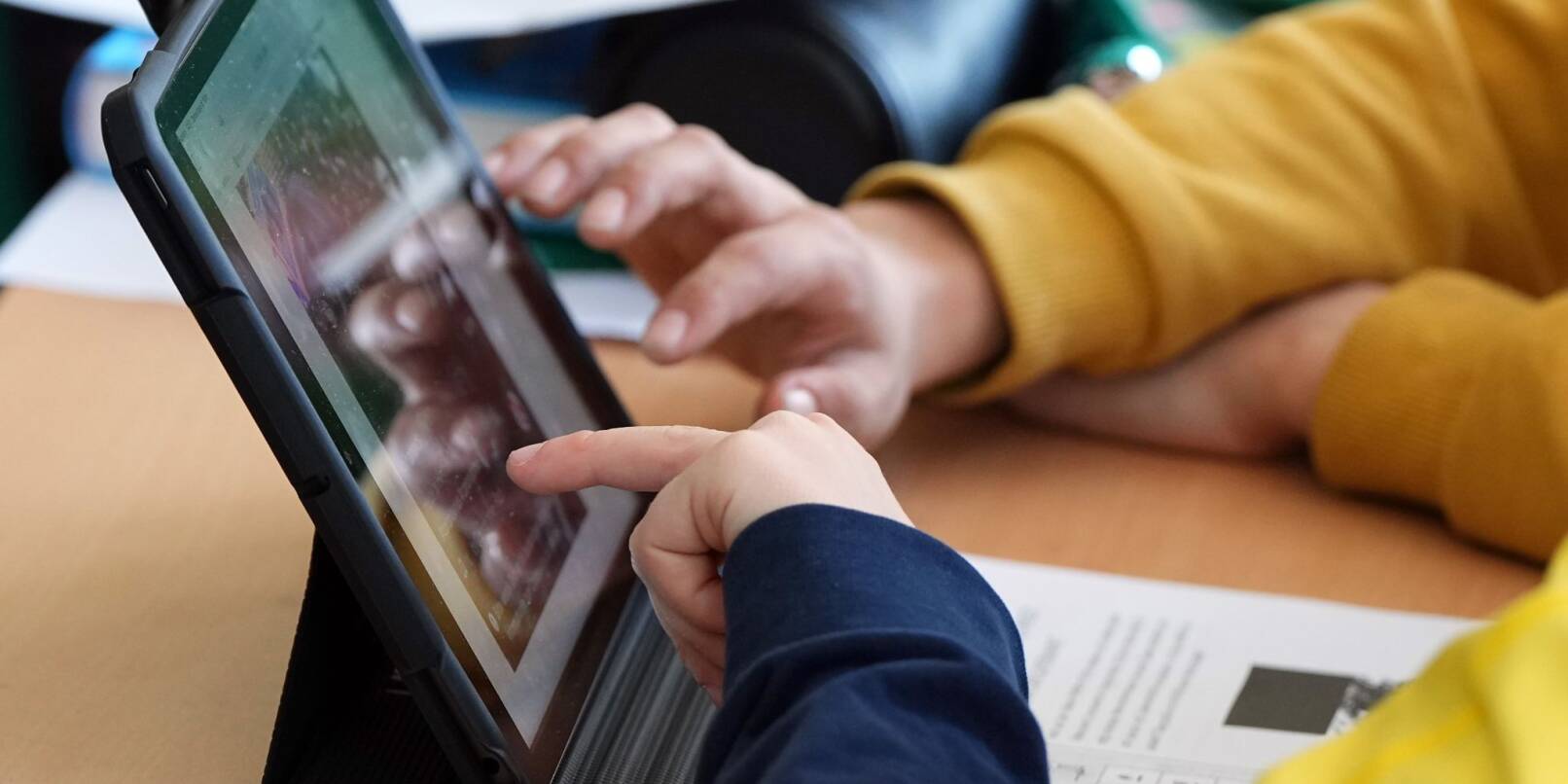Schüler einer Klasse der Berliner Hunsrück-Grundschule lösen im Unterricht an einem Tablet eine Aufgabe.
