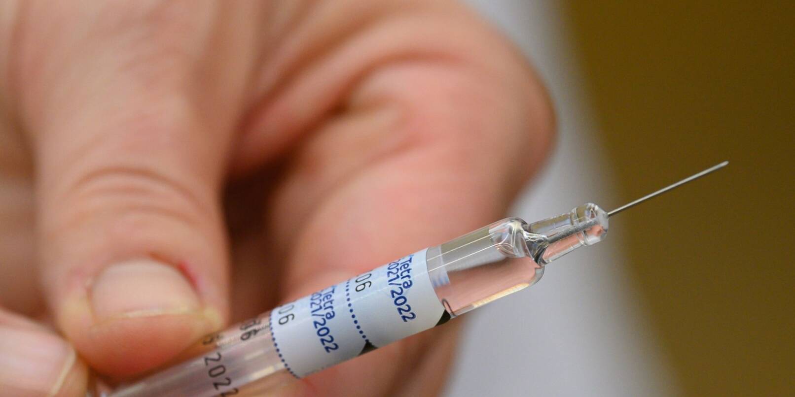 Eine Ärztin hält eine Spritze mit einem Wirkstoff gegen die Grippe in der Hand.