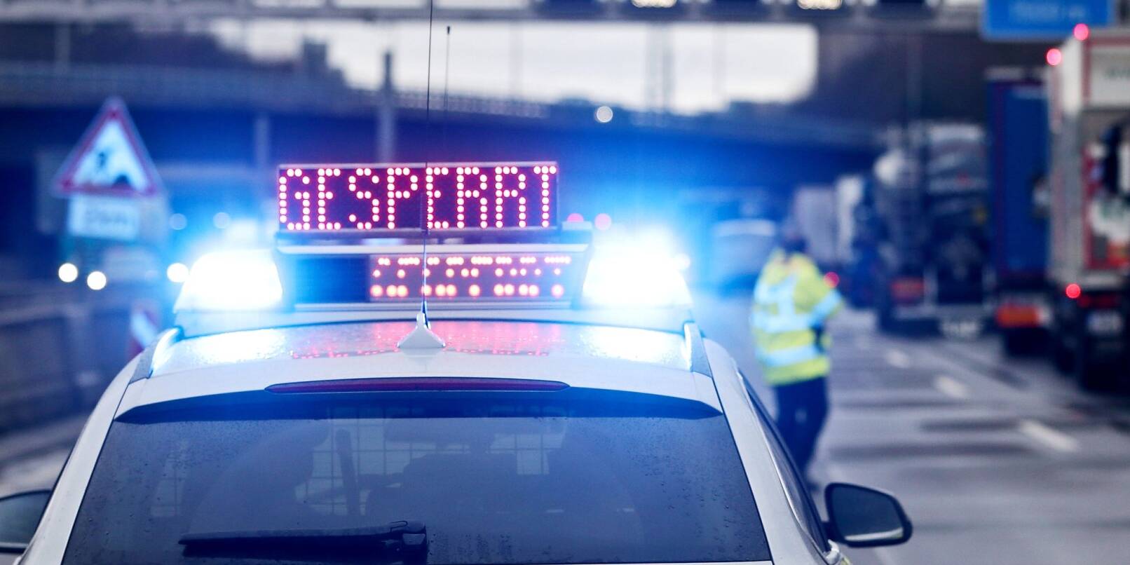 Auf einem Polizeifahrzeug leuchtet die Aufschrift «Gesperrt».