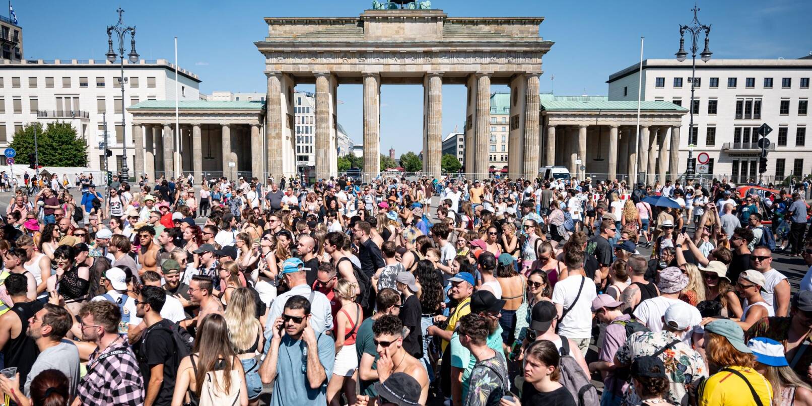 Menschen feiern vor dem Brandenburger Tor in Berlin zu Techno-Musik.