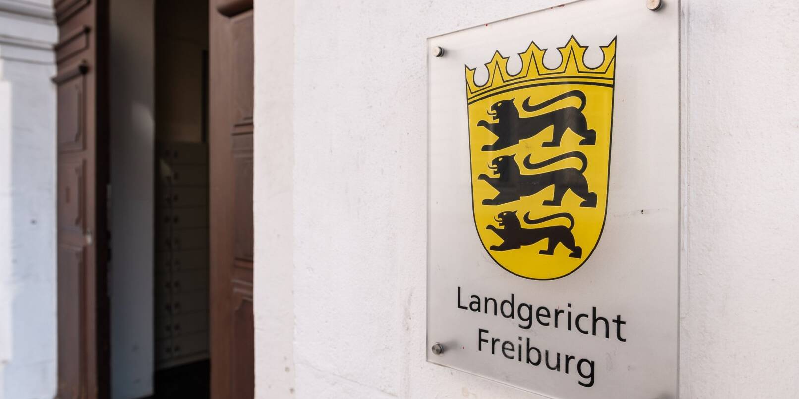Blick auf ein Schild mit der Aufschrift «Landgericht Freiburg» am Eingangsbereich des Gerichts.