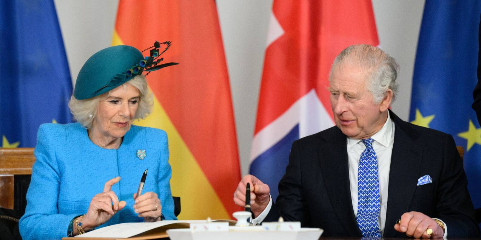 König Charles III. und Königsgemahlin Camilla tragen sich im Schloss Bellevue ins Gästebuch ein.
