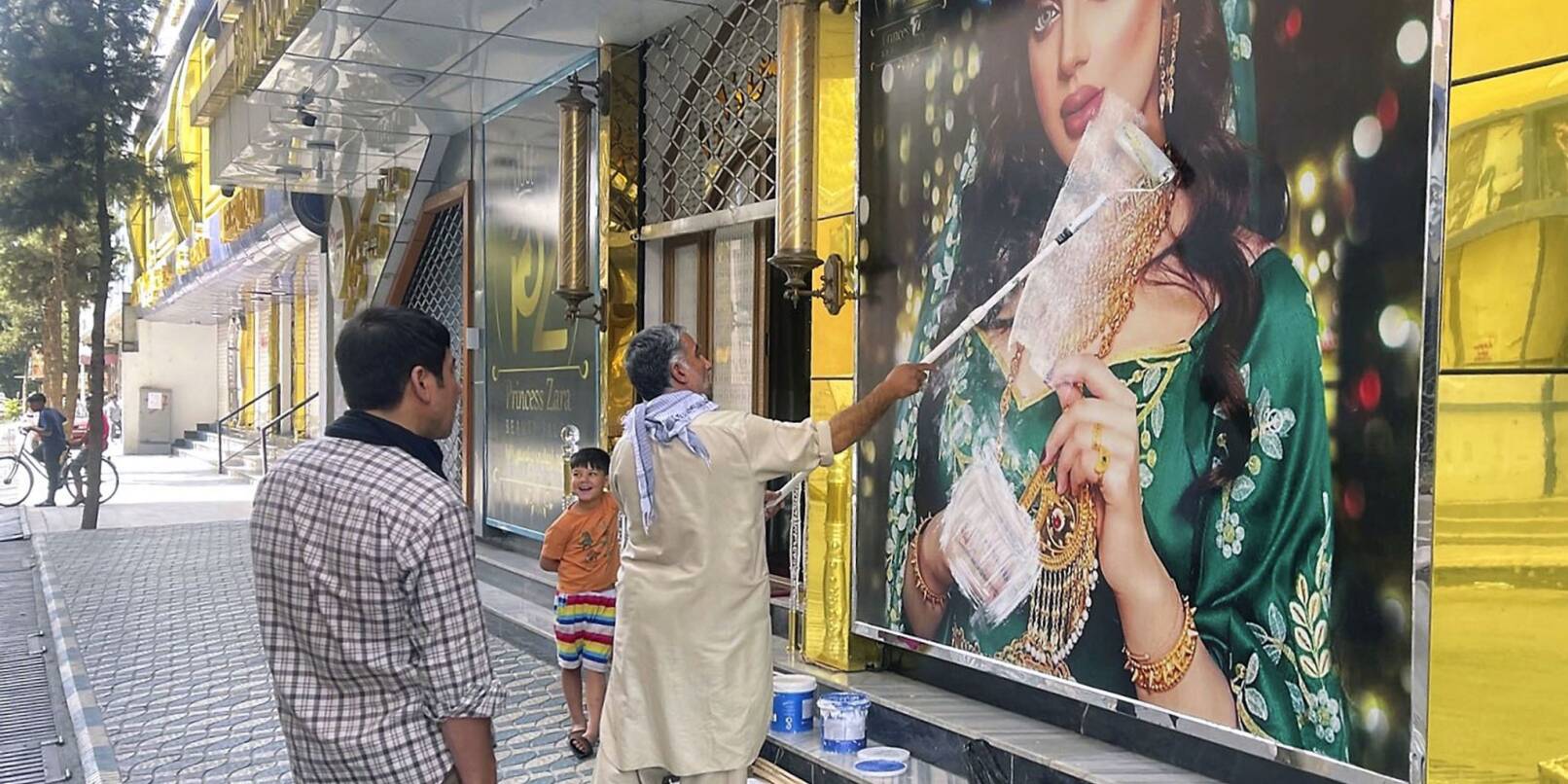 Ein Mitarbeiter eines Schönheitssalons übermalt nach der Machtübernahme der Taliban das Bild einer Frau in Kabul (Archivbild). Frauen haben in der afghanischen Hauptstadt gegen die Schließung der Salons protestiert. Ein Mitarbeiter eines Schönheitssalons übermalt nach der Machtübernahme der Taliban das Bild einer Frau in Kabul (Archivbild). Frauen haben in der afghanischen Hauptstadt gegen die Schließung der Salons protestiert.