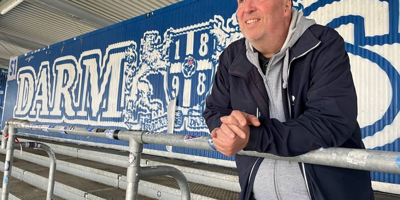 Erik Eichhorn, hauptamtlicher Fanbeauftragter des SV Darmstadt 98, genießt die Ruhe in seinem zweiten "Wohnzimmer", dem Stadion am Böllenfalltor. Normalerweise stehen auf der Südtribüne die Ultras des Zweitliga-Spitzenreiters.