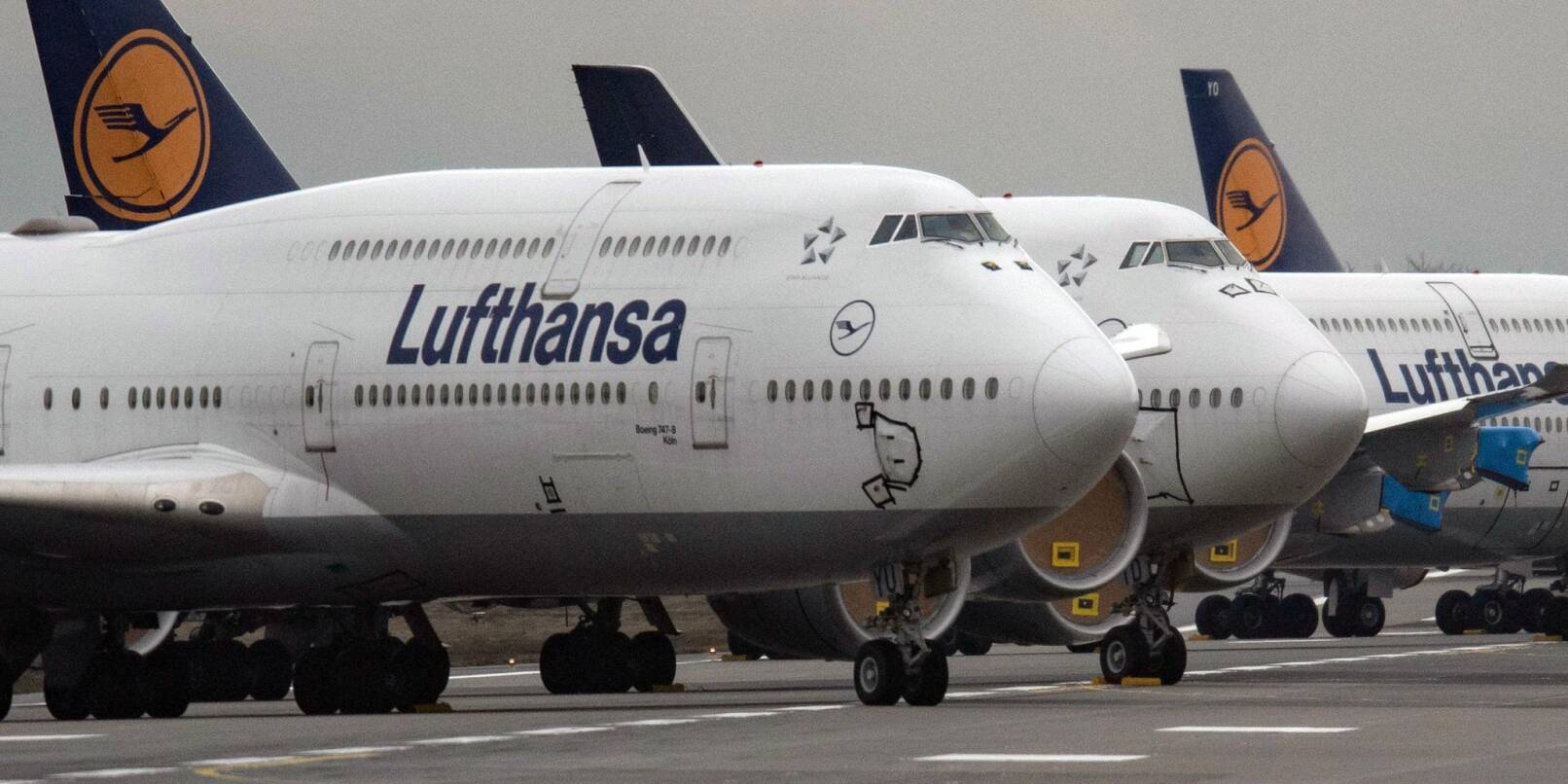 Flugzeuge von Lufthansa stehen auf einem Flughafen.