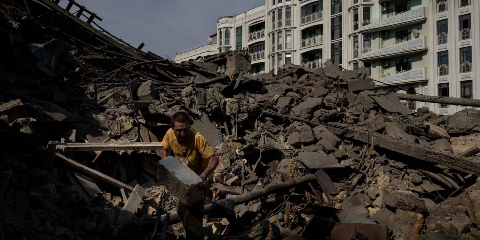 Ein Mann räumt Trümmer eines durch Raketenbeschuss zerstörten Wohnhauses in der Stadt Odessa weg.