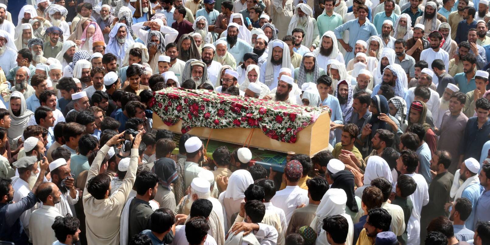 Trauernde nehmen in Bajur an der Beerdigung von Opfern der Bombenexplosion teil.