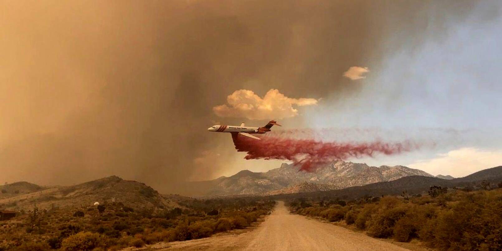 Ein Löschflugzeug ist über dem Mojave National Preserve im Einsatz, einem Schutzgebiet im US-Bundesstaat Kalifornien. Ein Löschflugzeug ist über dem Mojave National Preserve im Einsatz, einem Schutzgebiet im US-Bundesstaat Kalifornien.
