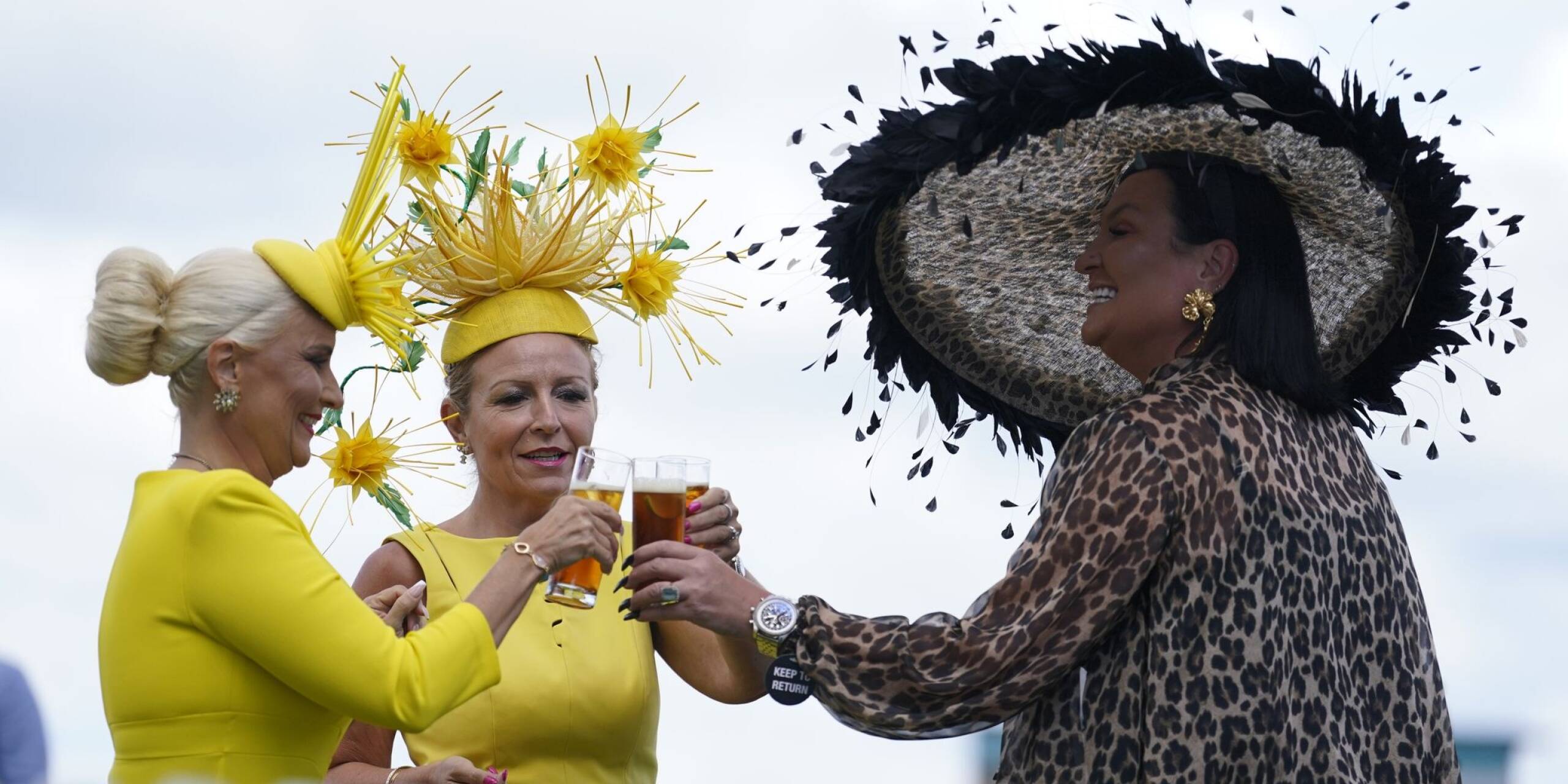 Frau trägt Hut: Beim Qatar Goodwood Festival stoßen Zuschauerinnen auf ein Pferderennen an. Die Veranstaltung ist in Großbritannien auch ein gesellschaftliches Ereignis.