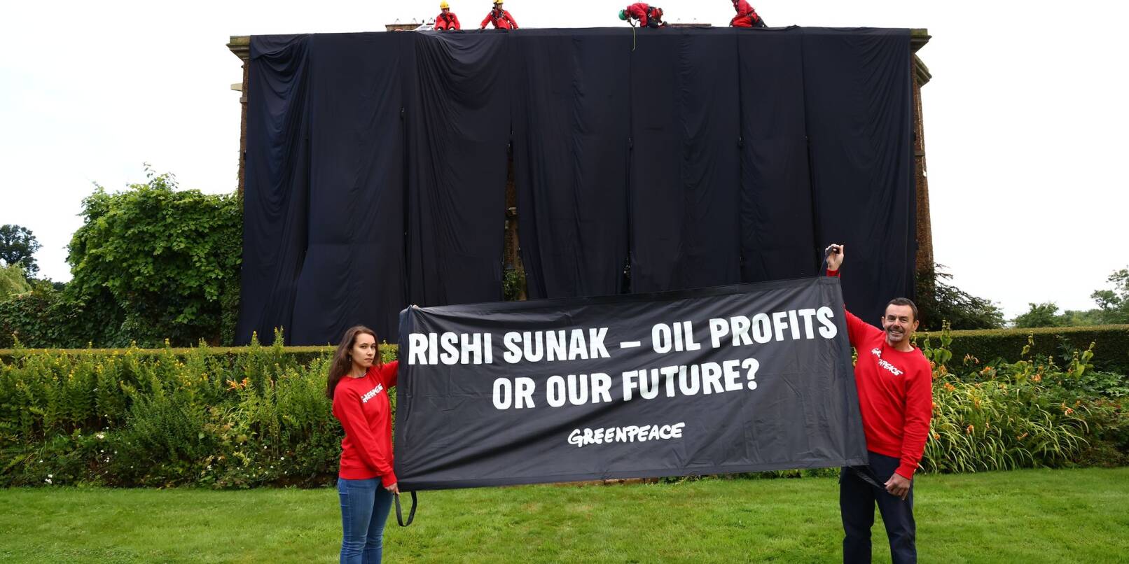 Greenpeace-Aktivisten mit einem Banner vor dem verhüllten Haus des britischen Premiers Rishi Sunak. Greenpeace-Aktivisten mit einem Banner vor dem verhüllten Haus des britischen Premiers Rishi Sunak.