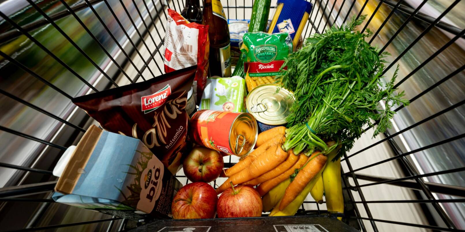 Lebensmittel liegen in einem Einkaufswagen in einem Supermarkt.
