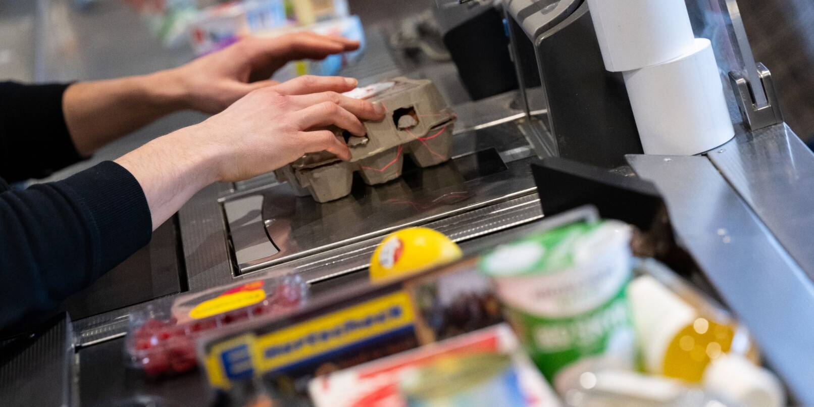 Ein Kassierer arbeitet in einem Supermarkt: Die Inflationsrate sinkt.