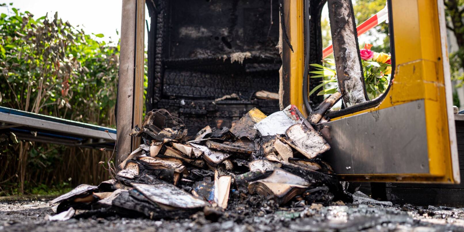 Verbrannte Bücher liegen in der ausgebrannten Bücherbox in der Nähe des Mahnmals «Gleis 17». Dem Täter ist die Polizei möglicherweise auf der Spur.