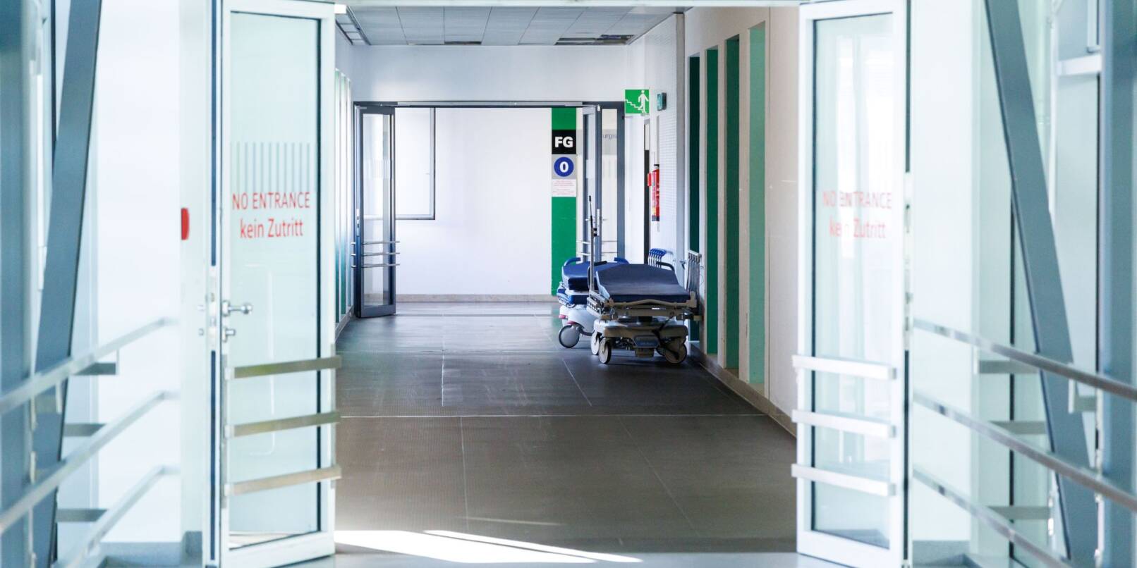 Krankenbetten stehen in einem Gang in einem Krankenhaus.