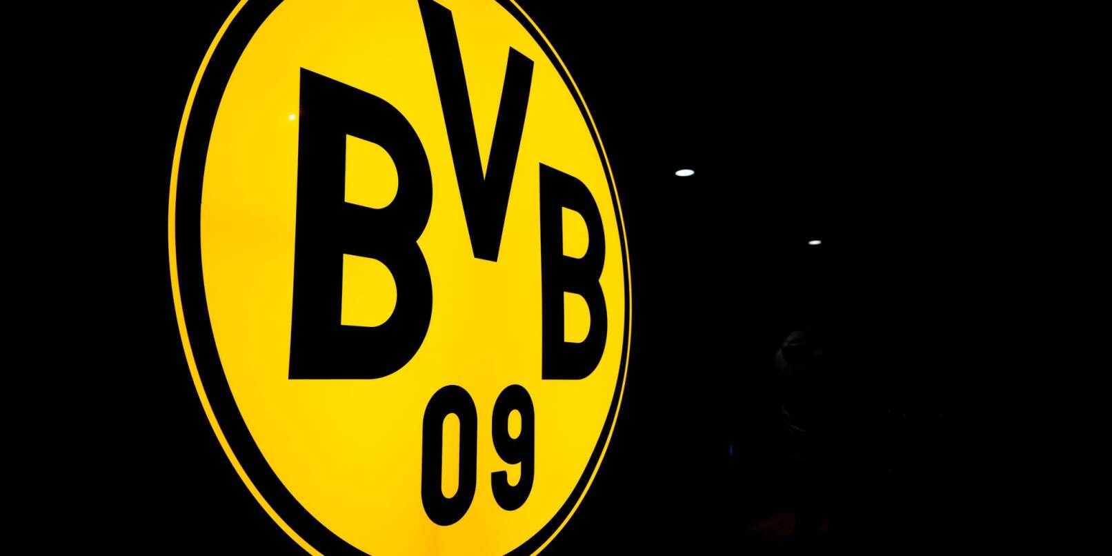 Das Logo des BVB leuchtet in der Dunkelheit.