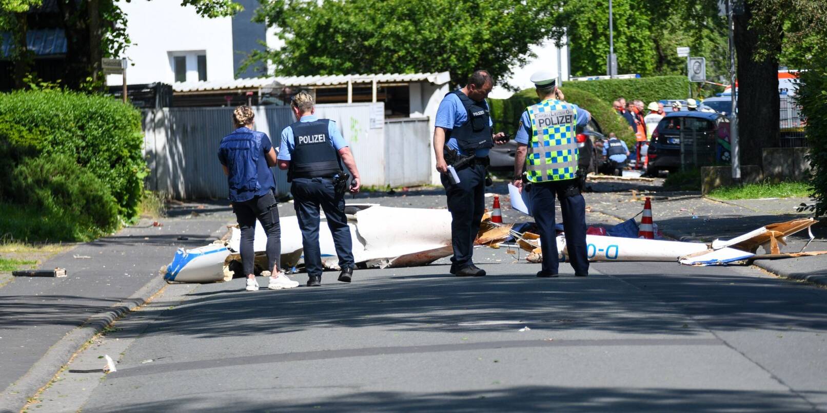 Trümmer liegen auf der Straße nach dem Absturz eines Leichtflugzeugs. Trümmer liegen auf der Straße nach dem Absturz eines Leichtflugzeugs.