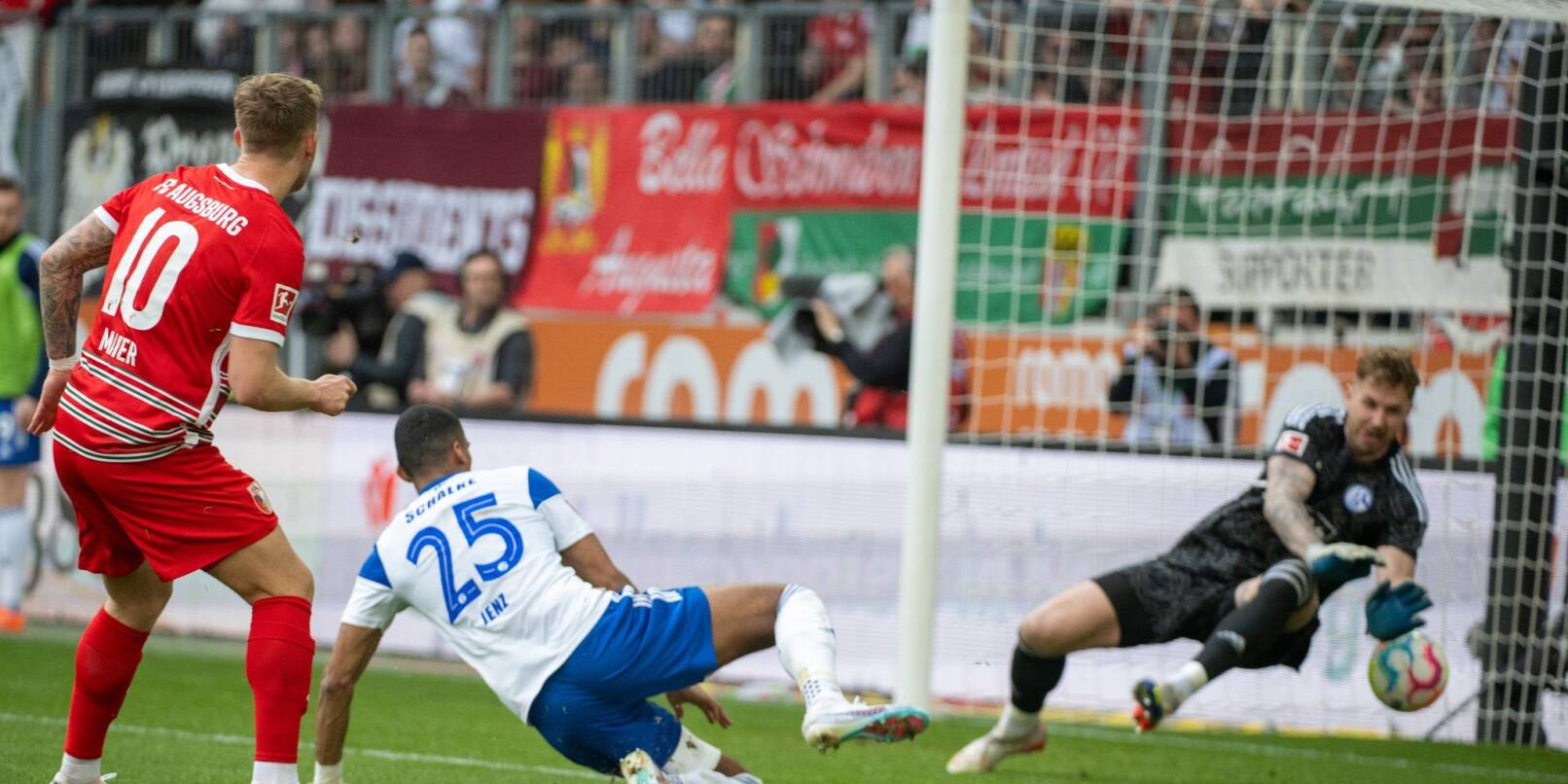 Schalkes Torwart Ralf Fährmann (r) und Moritz Jenz können das Tor von Augsburgs Arne Maier (l) nicht verhindern.