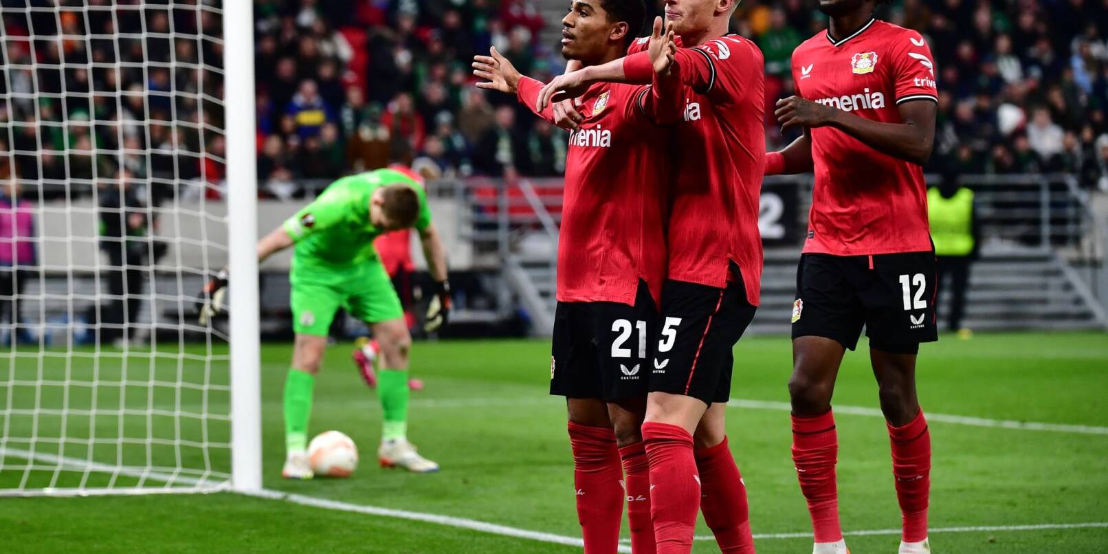 Leverkusens Torschütze Amine Adli (l-r) jubelt nach seinem Tor zum 0:2 mit Mitchel Bakker und Edmond Tapsoba.