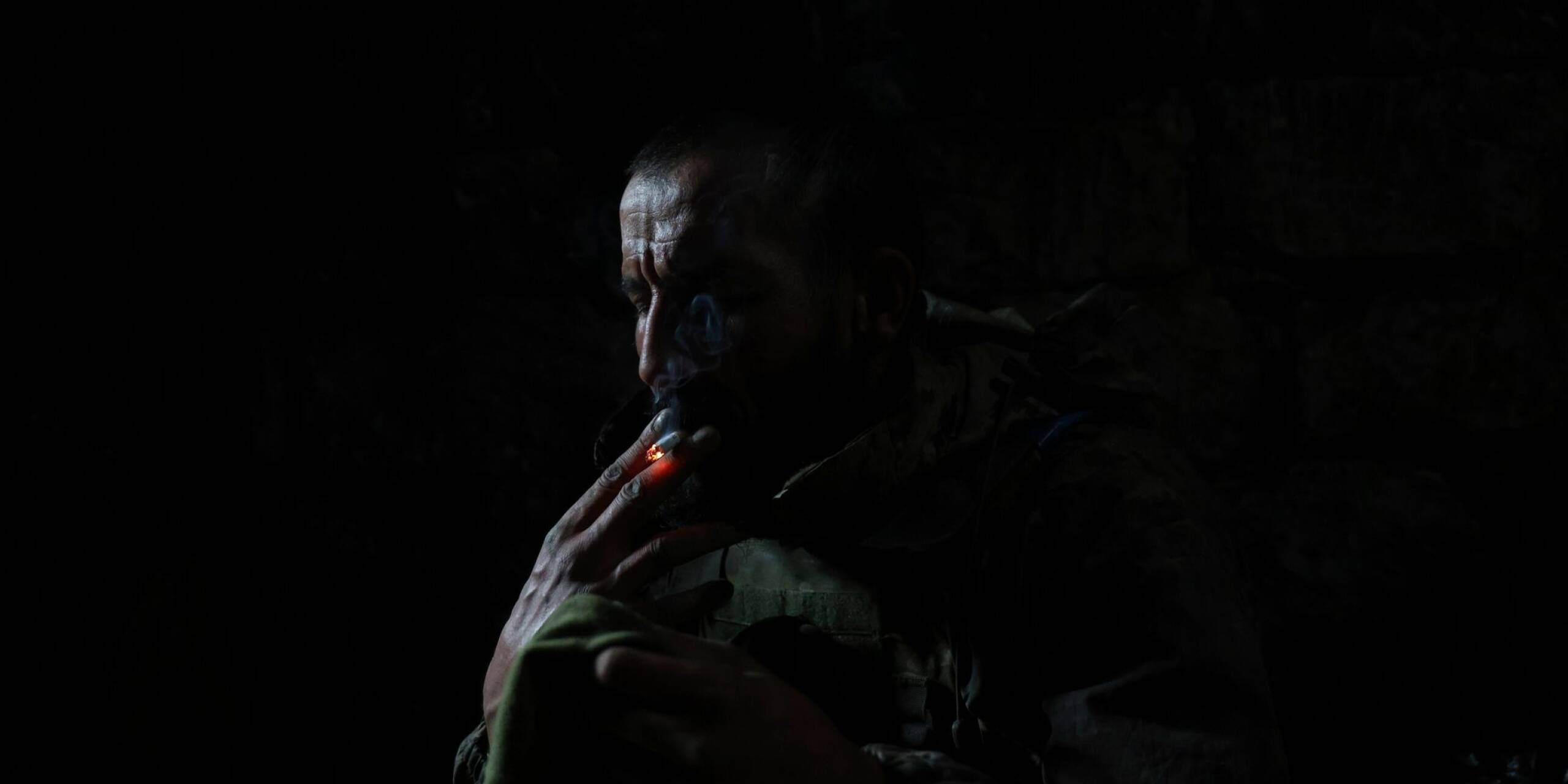 Ein ukrainischer Soldat raucht eine Zigarette, während er in einem Bunker an der Frontlinie bei Andrijewka Schutz vor Beschuss sucht.