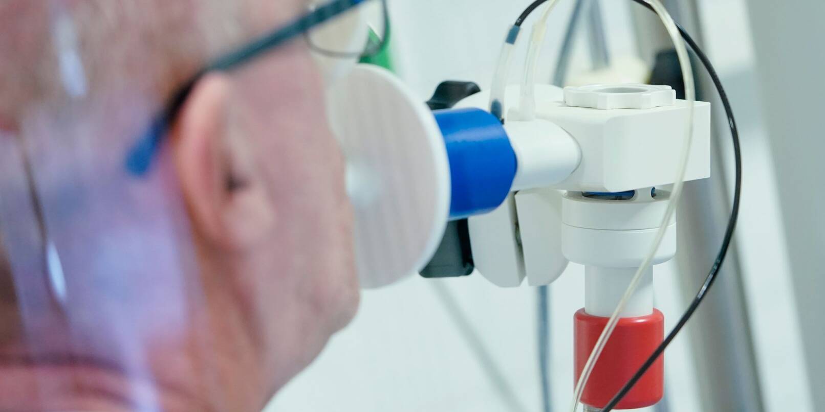 Ein von einer Corona-Erkrankung genesener Patient bekommt in einer Lungentest-Kabine in einer Rehaklinik die Lungenfunktion gemessen.