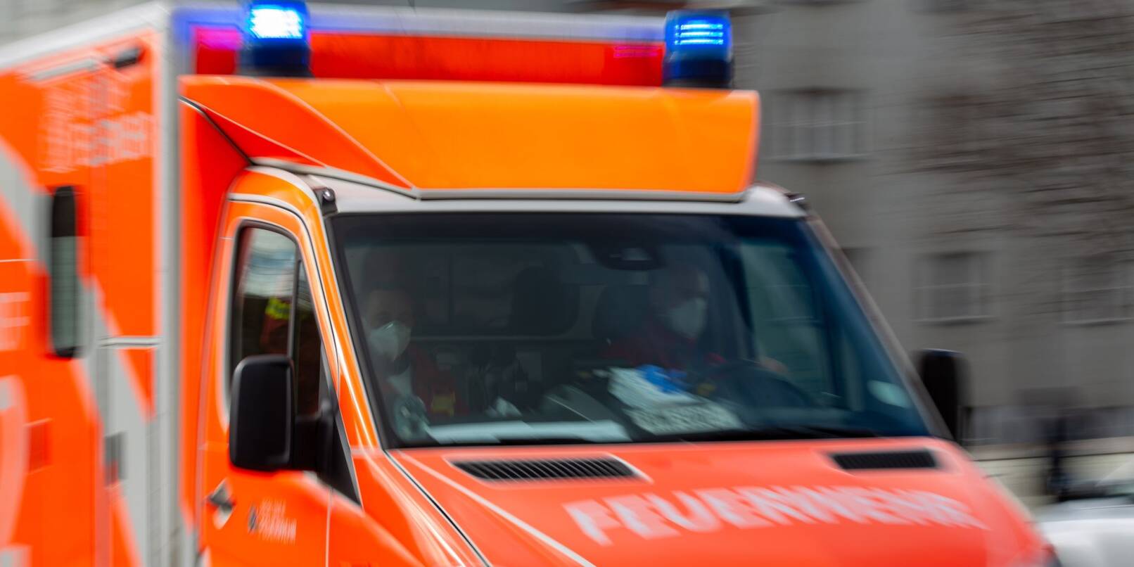 Ein Rettungswagen der Feuerwehr fährt auf einer Straße. Ein Rettungswagen der Feuerwehr fährt auf einer Straße.