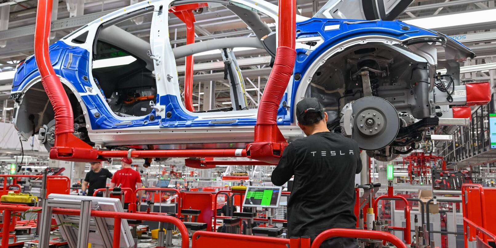 Ein Mitarbeiter arbeitet im Tesla-Werk Berlin Brandenburg an einer Fertigungslinie für Elektrofahrzeuge vom Typ Model Y.