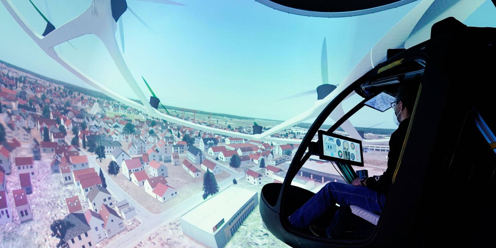 Ein Mitarbeiter des Flugtaxi-Entwicklers Volocopter sitzt in einem Entwicklungslabor im Cockpit eines Entwicklungssimulators.