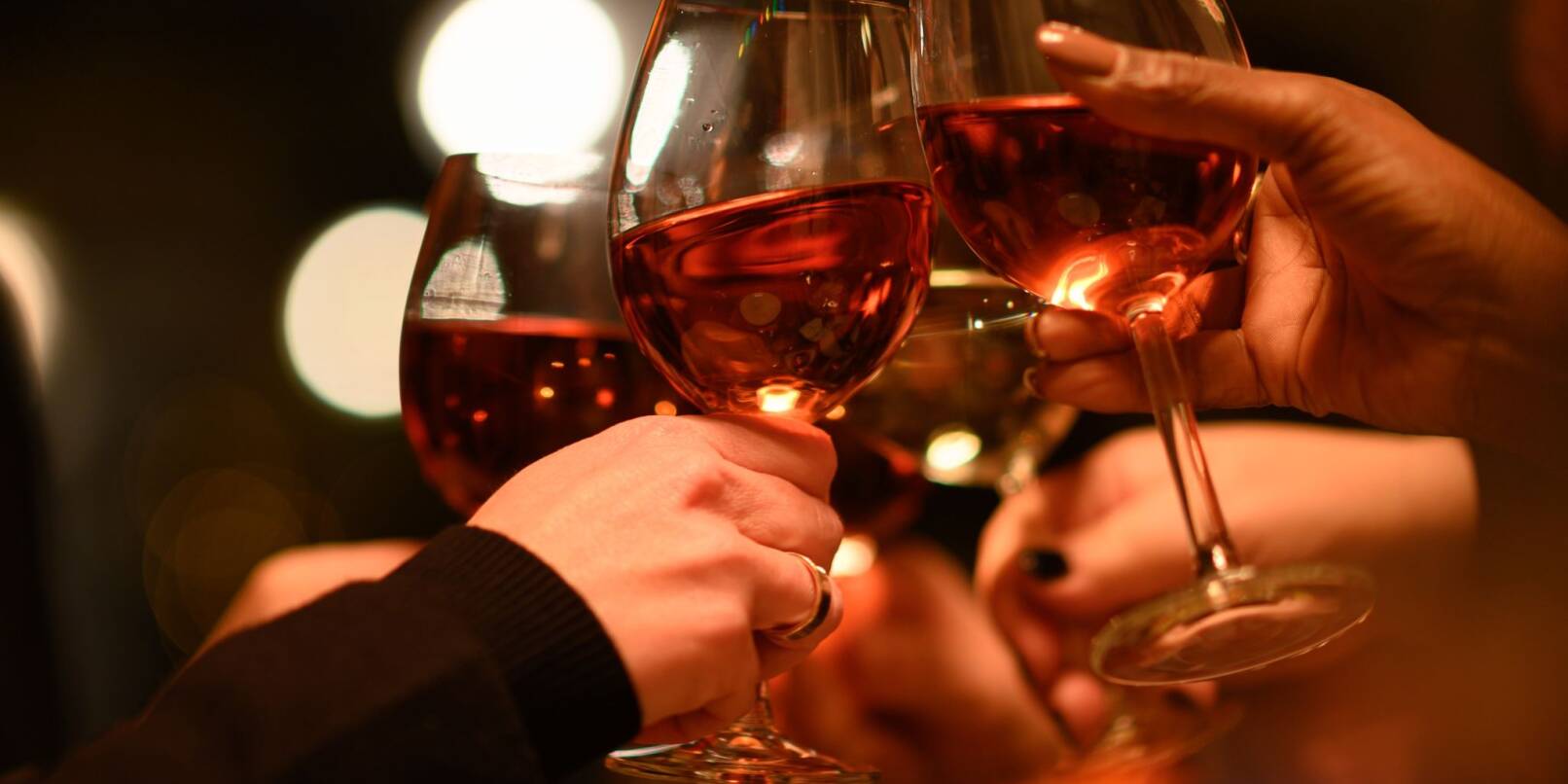 Gäste stoßen in einem Restaurant mit ihren Weingläsern an.