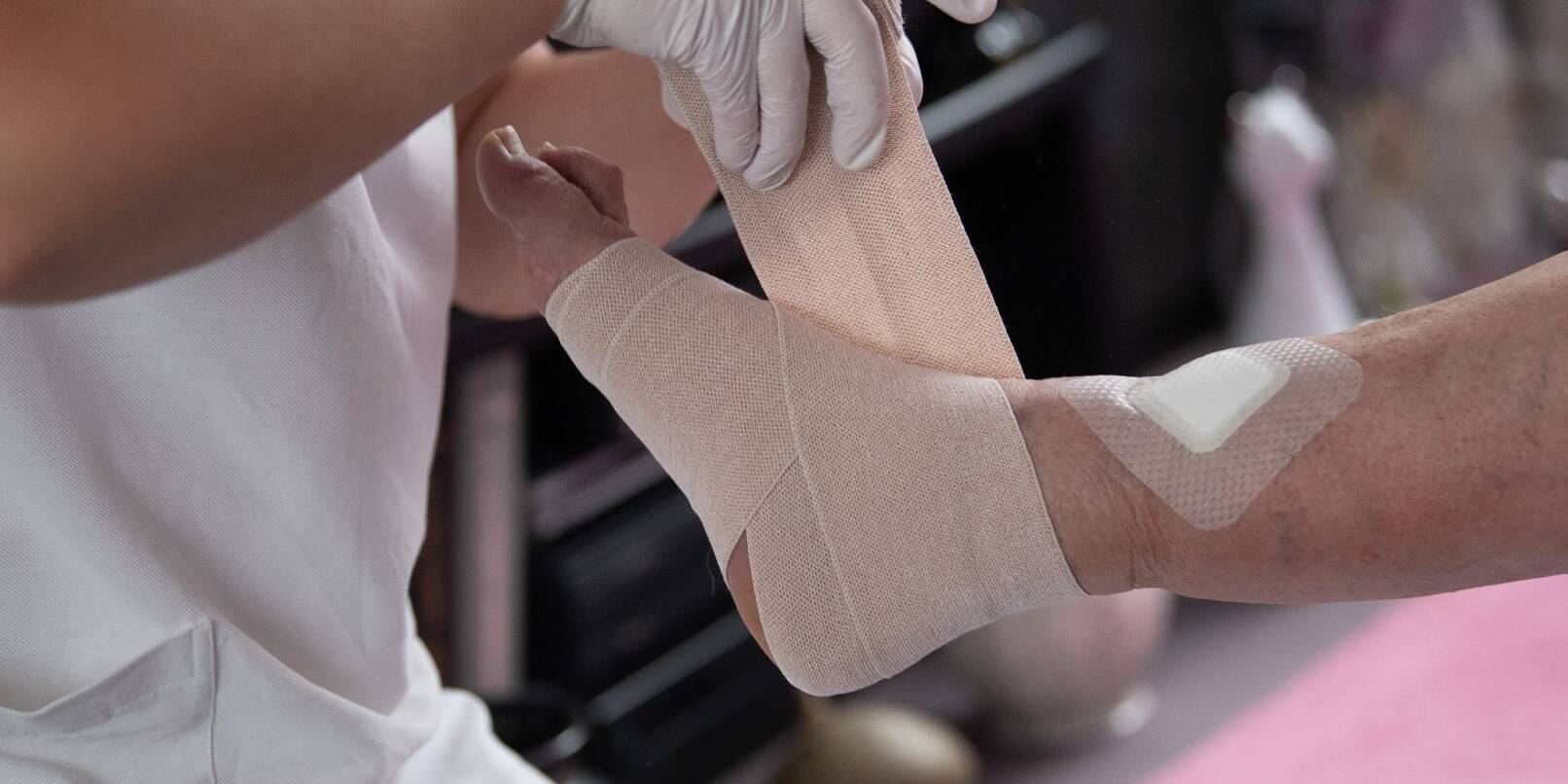Eine Pflegefachkraft legt in der ambulanten Pflege einen Kompressionsverband an. Eine Pflegefachkraft legt in der ambulanten Pflege einen Kompressionsverband an.