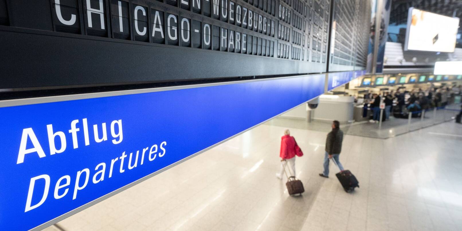 Reisegäste gehen an einem Flughafen zum Abflugterminal. Reisegäste gehen an einem Flughafen zum Abflugterminal.