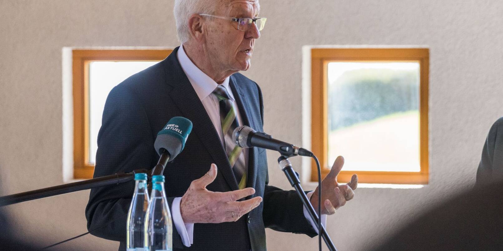 Ministerpräsident Winfried Kretschmann (Bündnis 90 / Die Grünen) steht in der Kapelle der Ortschaft Ried und spricht.