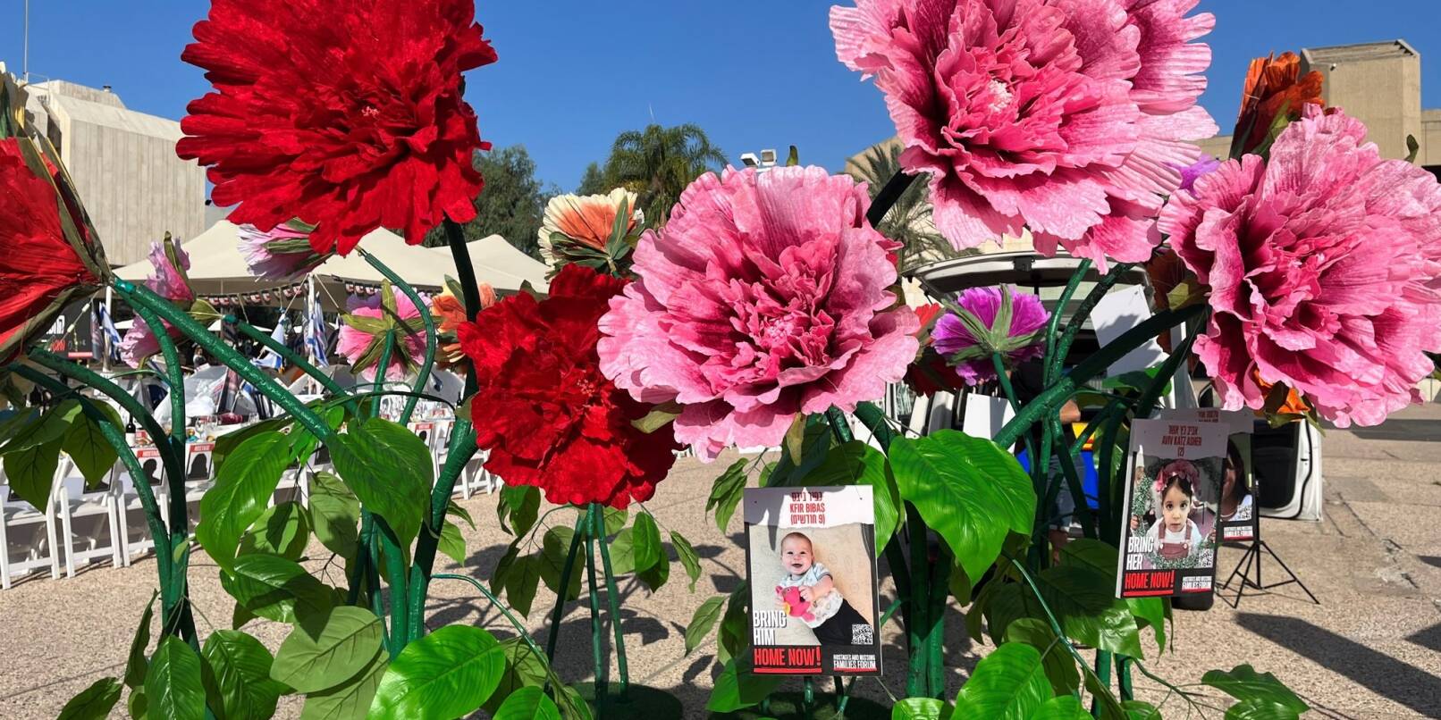 Blumen mit Bildern von Kindern, die seit dem Massaker der Hamas im israelischen Grenzgebiet am 07. Oktober als Geiseln gehalten und vermisst werden, stehen vor dem Kunstmuseum in Tel Aviv.