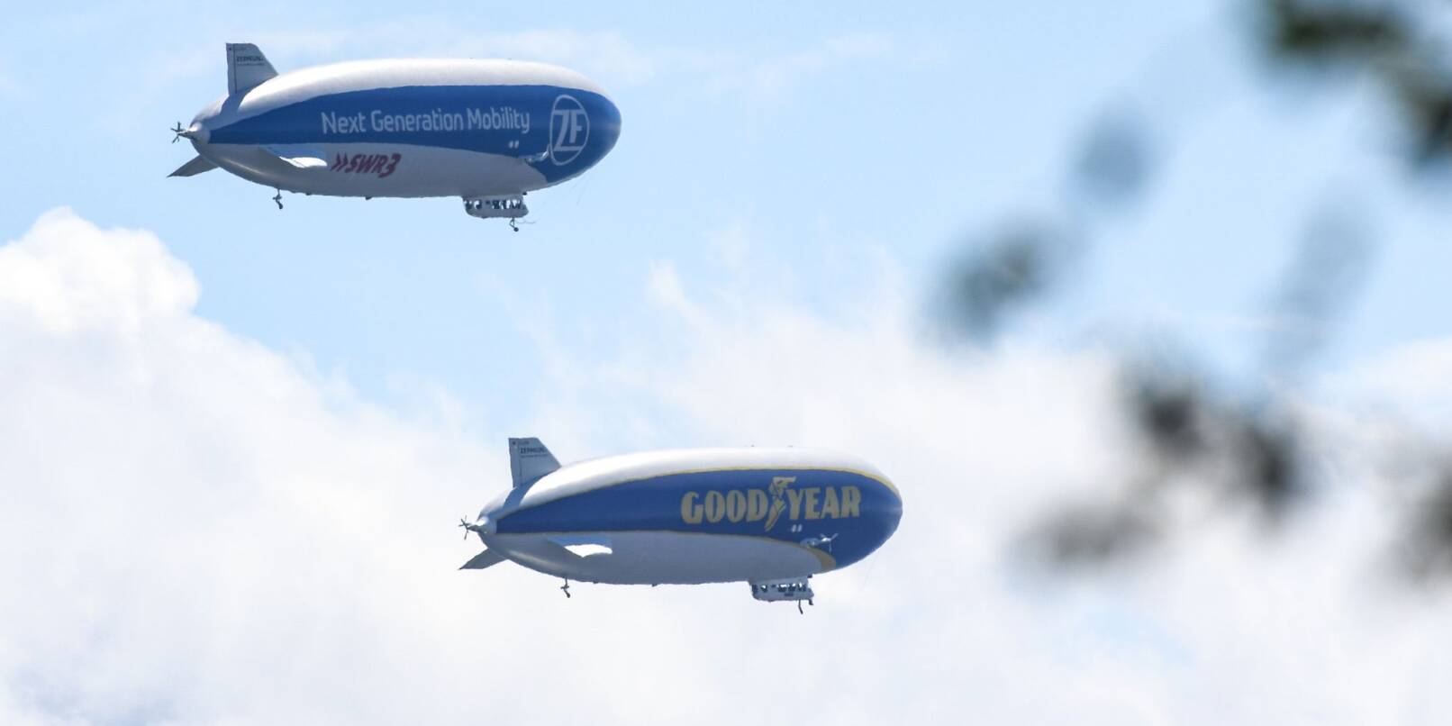 Zwei Zeppeline fliegen über Friedrichshafen.