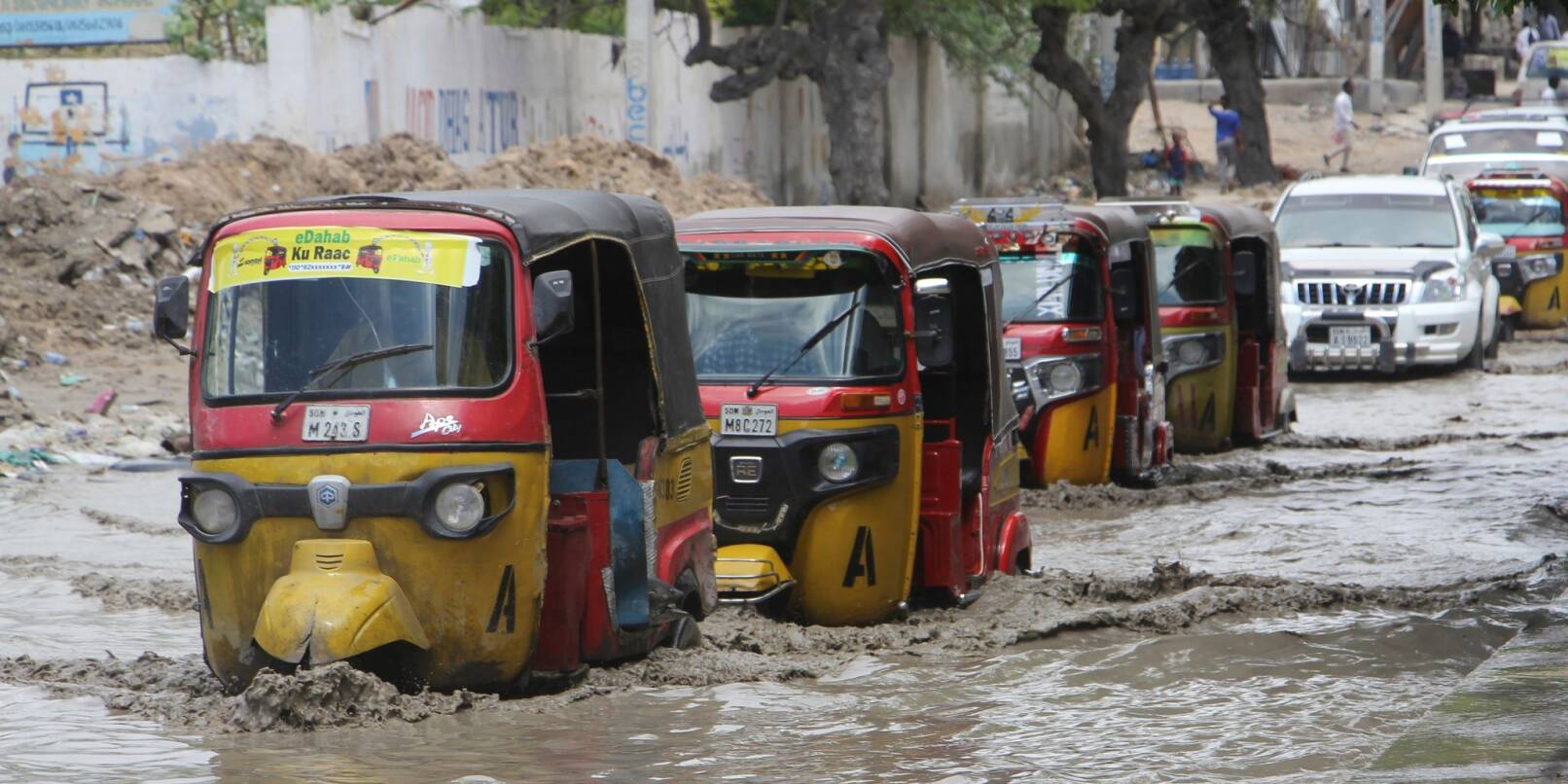 Tuktuks fahren durch eine überflutete Straße nach starkem Regen in Mogadischu.