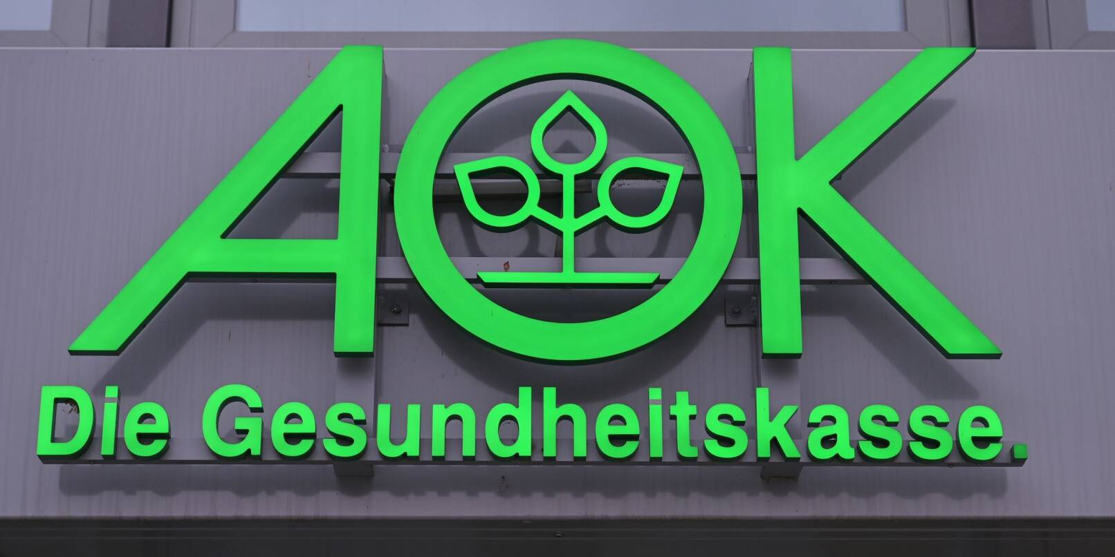 Das Logo der AOK, Allgemeine Ortskrankenkasse, ist an einem Gebäude zu sehen.