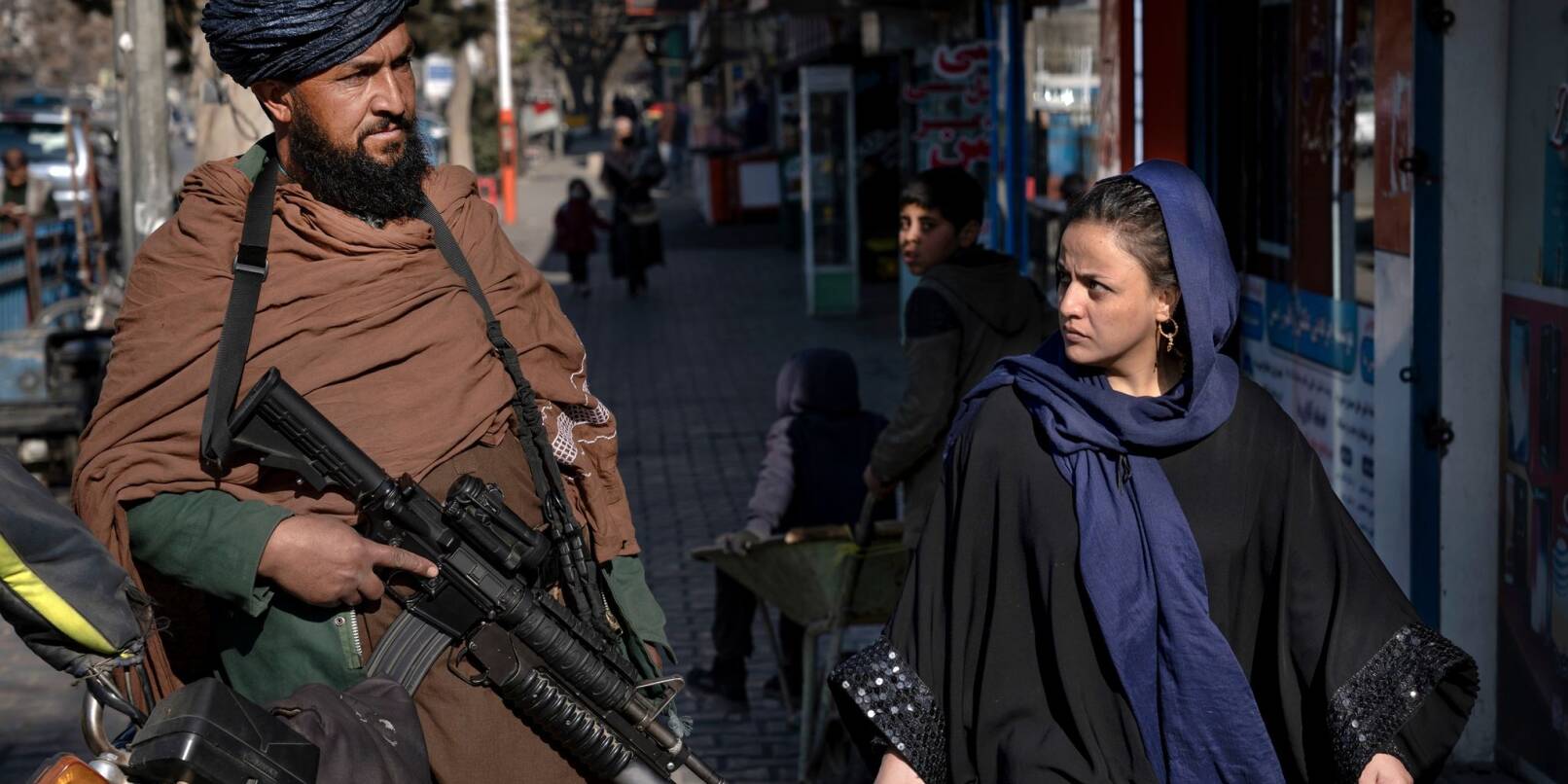Ein Taliban-Kämpfer und eine Passantin in Afghanistans Haupstadt Kabul.