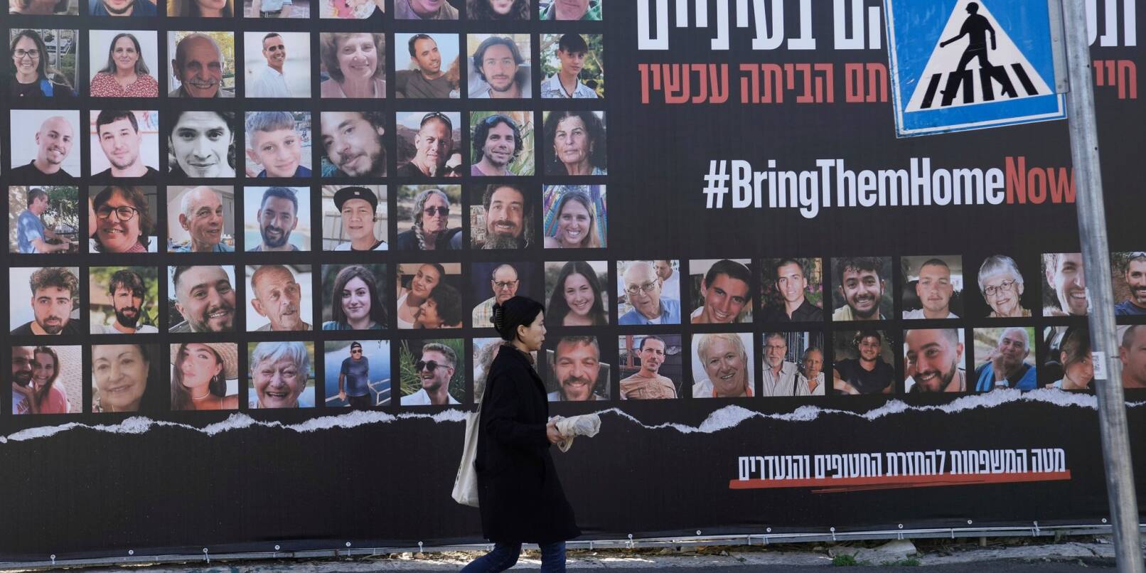 Eine Frau geht in Jerusalem an einem Plakat vorbei, das die Rückkehr der etwa 240 Geiseln fordert.