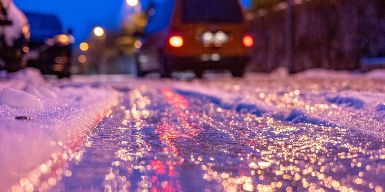 Eine dünne Eisschicht überzieht am frühen Morgen eine Straße.