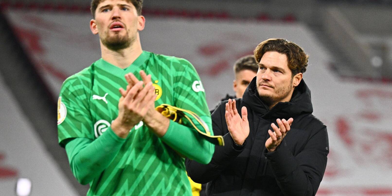 Dortmunds Torwart Gregor Kobel (l) und Trainer Edin Terzic verabscheden sich nach dem Pokal-Aus von den Fans.