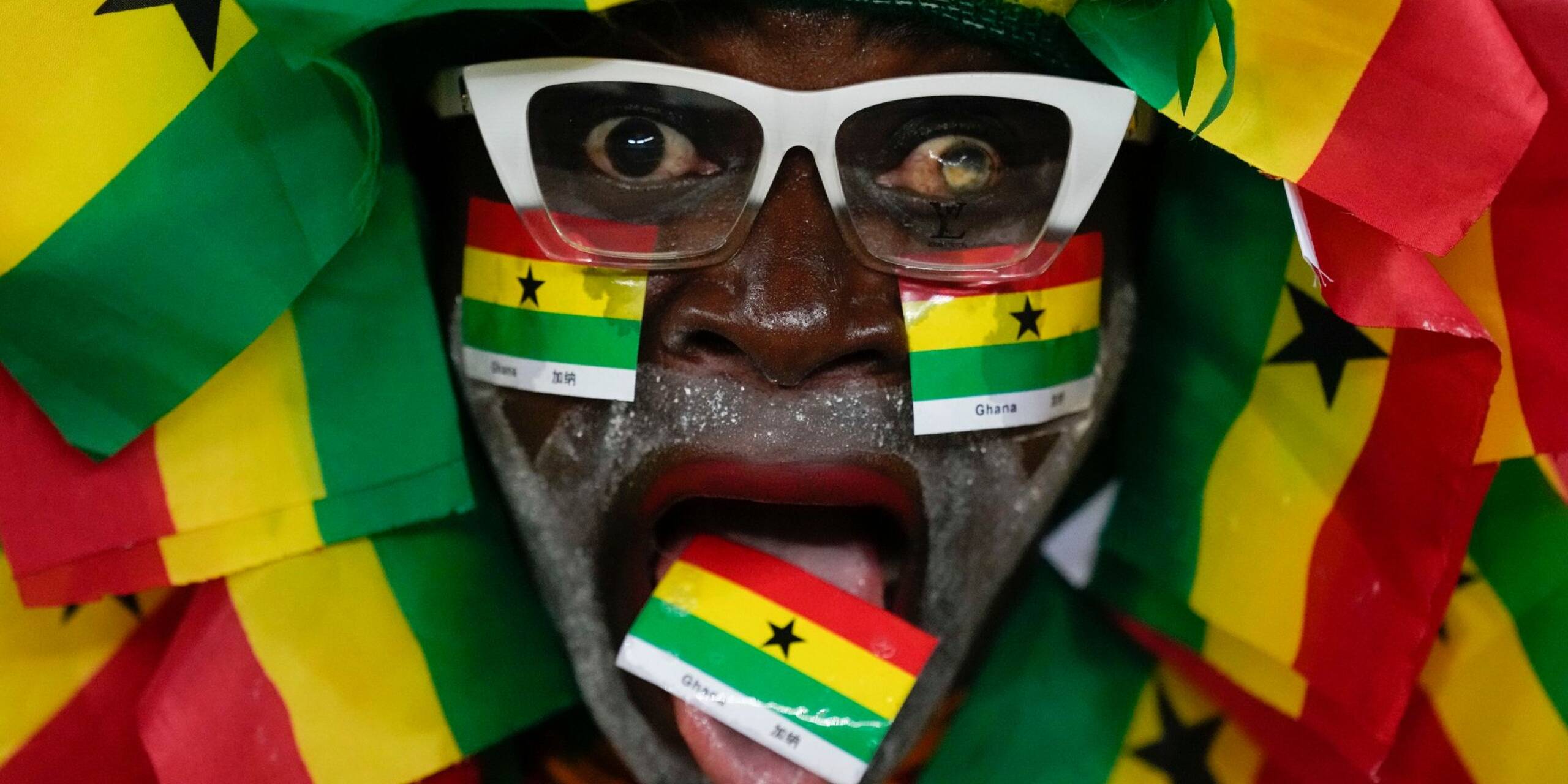 Dieser Fußballfan zeigt seine Liebe zum Land: Umgeben von den Farben Ghanas jubelt er vor dem Beginn des Spiels im Afrika-Cup.