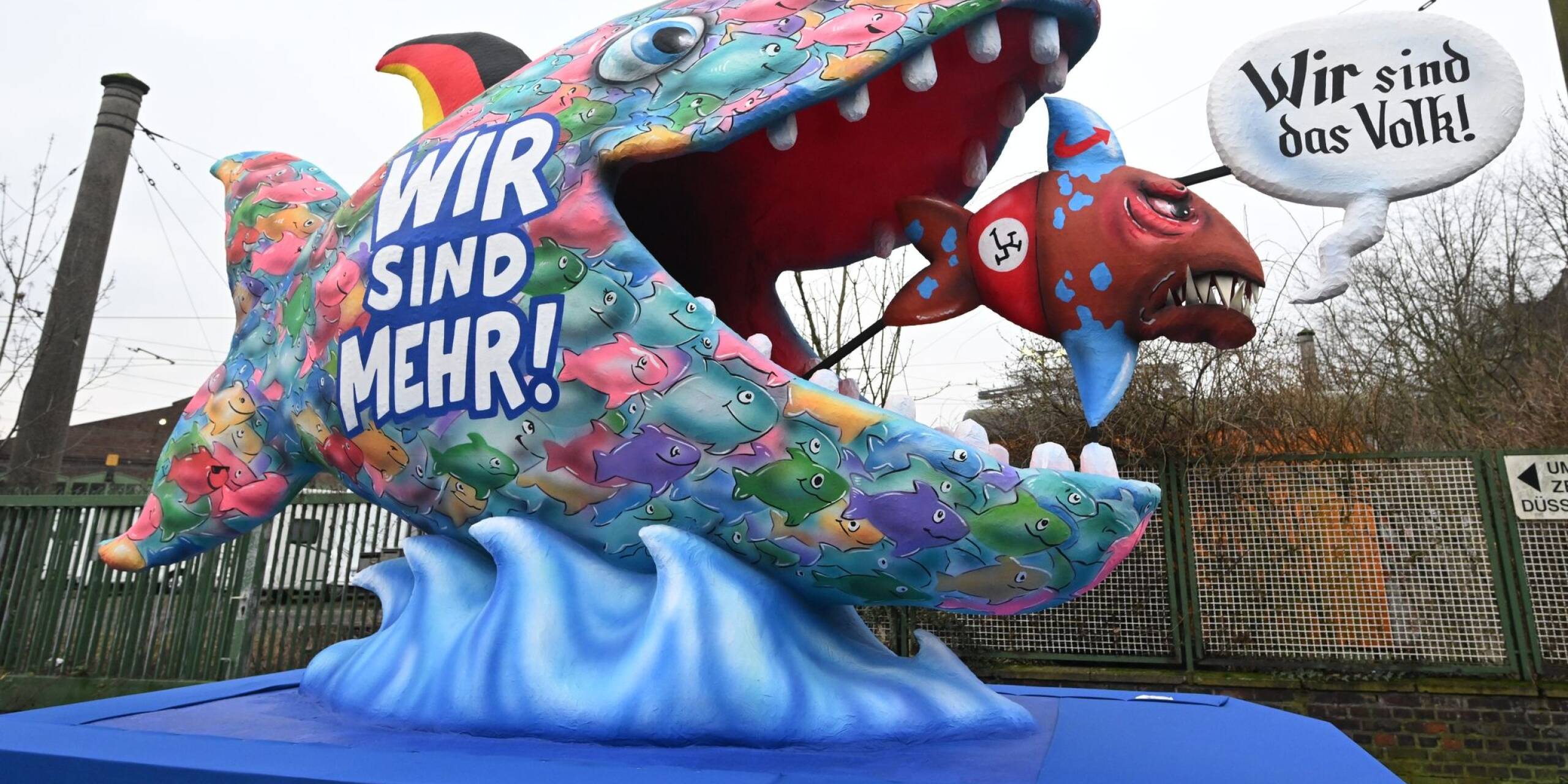 Eindeutige Botschaft beim Düsseldorfer Straßenkarneval: Ein großer bunter Fisch mit schwarz-rot-goldener Flosse verschlingt einen kleineren mit AfD-Logo auf der Flosse.
