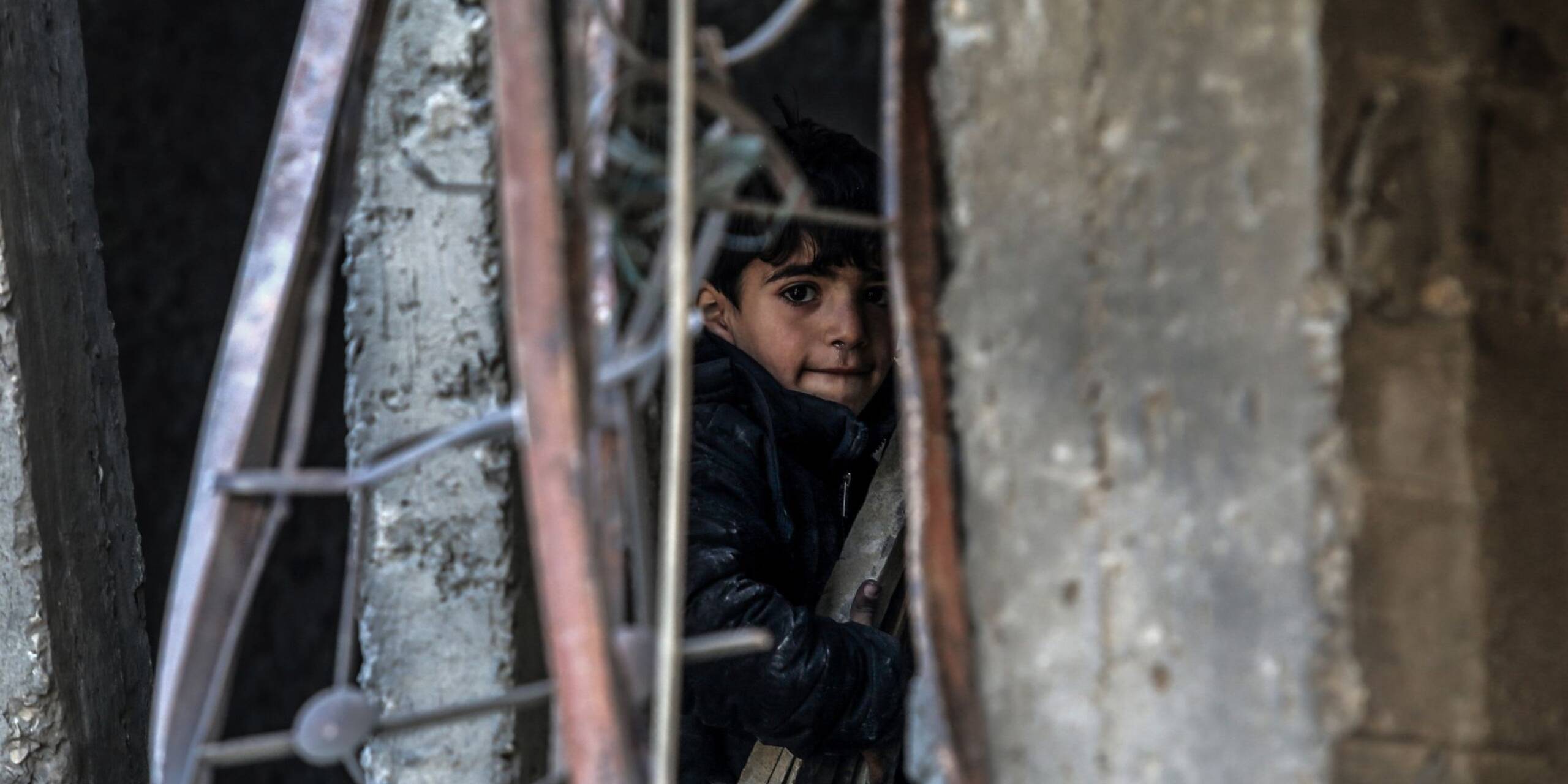 Bei israelischen Angriffen im Zuge einer Geiselbefreiungsaktion im Bereich der Stadt Rafah im Gazastreifen sind Dutzende Palästinenser getötet worden. Ein palästinensisches Kind sitzt zwischen den Trümmern.